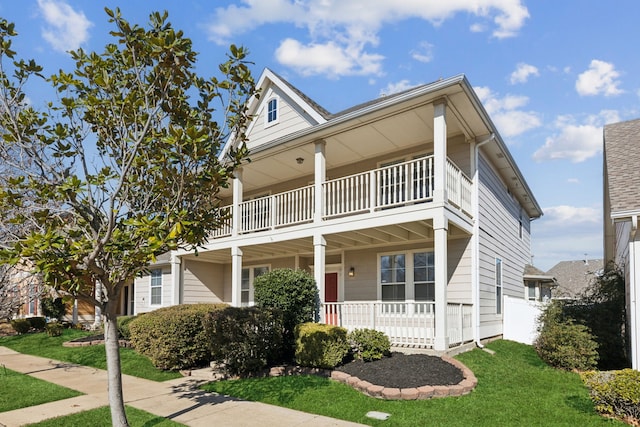 view of front of home featuring a front yard, a porch, and a balcony