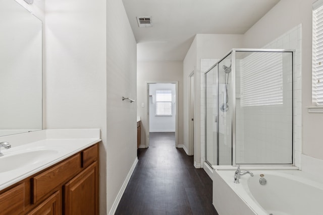 bathroom with wood-type flooring, vanity, and shower with separate bathtub