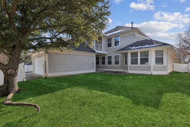 rear view of house featuring a garage and a yard