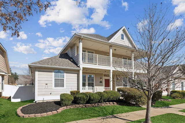 view of front of home featuring a balcony, covered porch, and a front yard