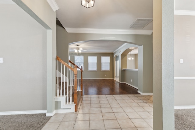 tiled entrance foyer featuring ceiling fan and ornamental molding