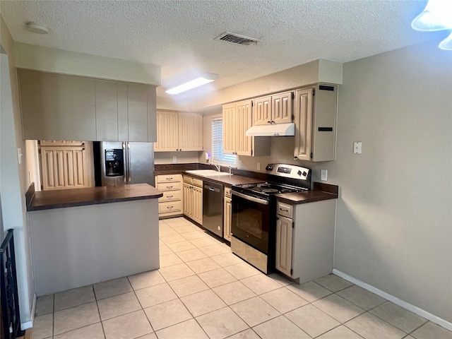 kitchen with light tile patterned floors, sink, a textured ceiling, and appliances with stainless steel finishes