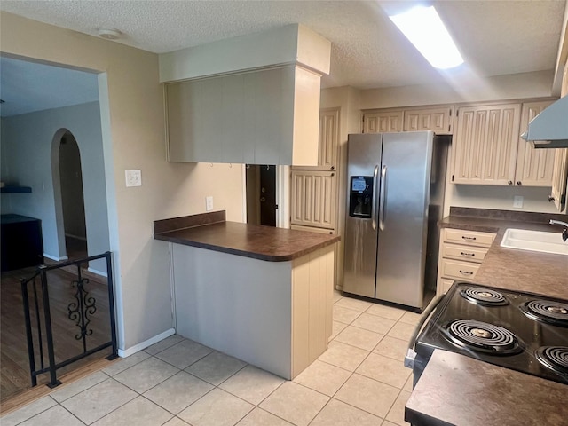 kitchen featuring light tile patterned flooring, stainless steel fridge, electric range, and sink