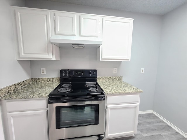 kitchen with electric stove, white cabinetry, light hardwood / wood-style flooring, and light stone countertops