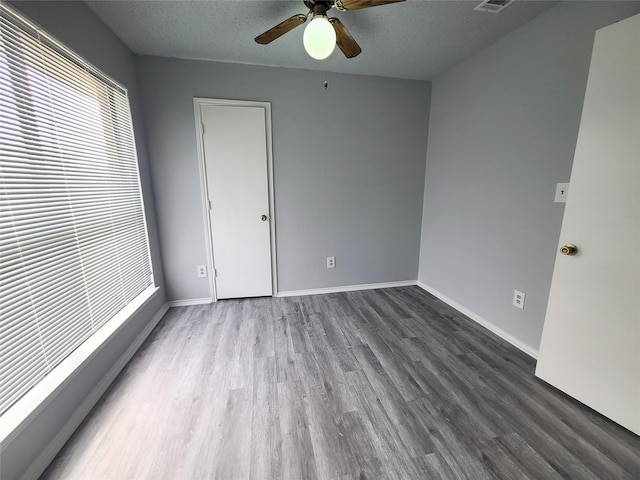 unfurnished bedroom with hardwood / wood-style flooring, a textured ceiling, and ceiling fan