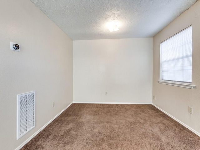 carpeted spare room with a textured ceiling