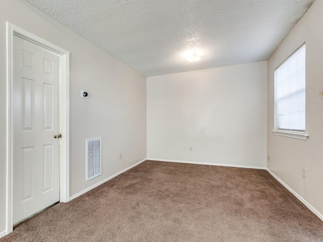 unfurnished room with carpet floors and a textured ceiling