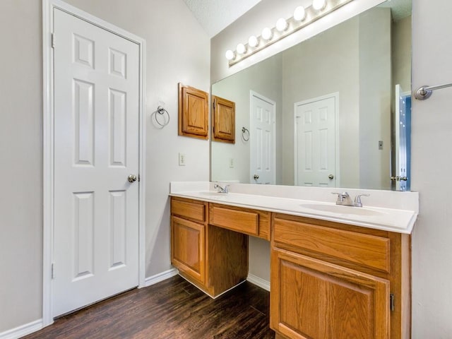 bathroom with a textured ceiling, hardwood / wood-style flooring, and vanity