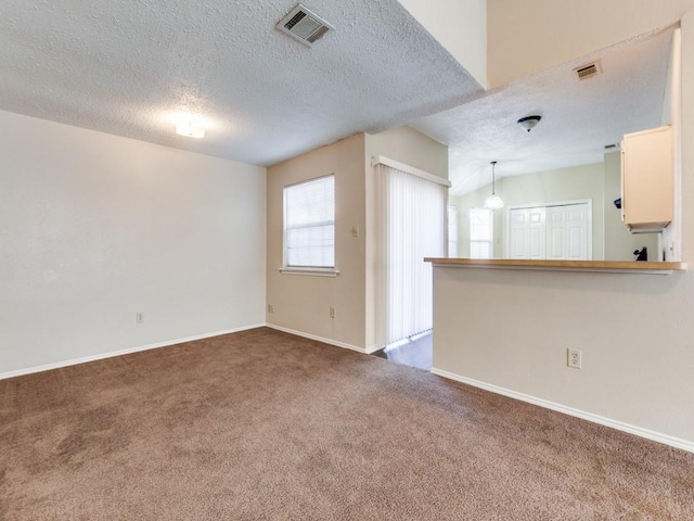 unfurnished living room featuring a textured ceiling, carpet flooring, and vaulted ceiling