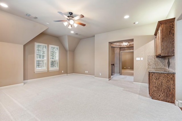 additional living space with ceiling fan and light colored carpet