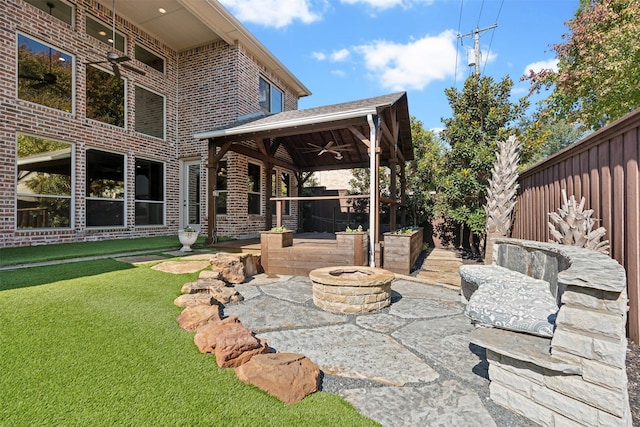 view of patio featuring ceiling fan and a fire pit