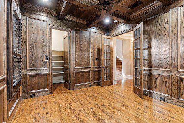 interior space featuring light hardwood / wood-style floors, ceiling fan, beamed ceiling, and coffered ceiling