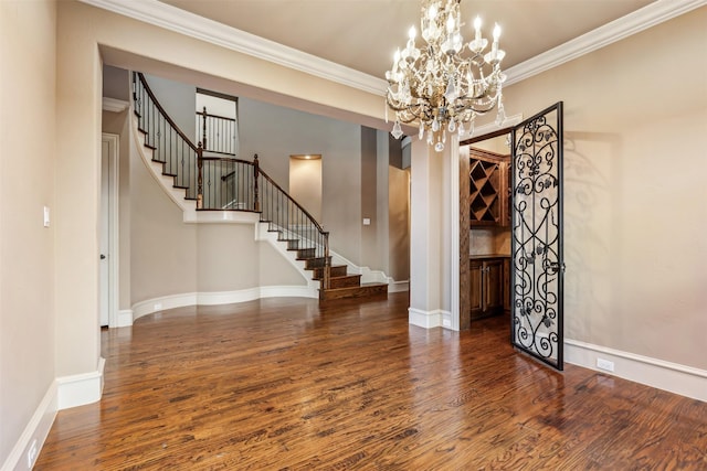 interior space with dark hardwood / wood-style flooring, crown molding, and an inviting chandelier