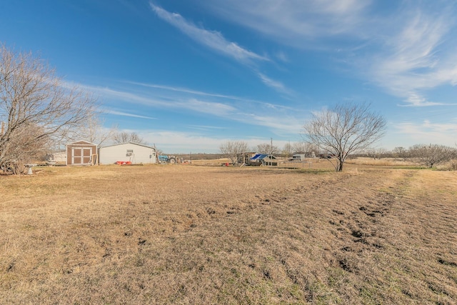 view of yard with a storage shed and a rural view