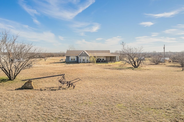 view of front facade featuring a front lawn and a rural view