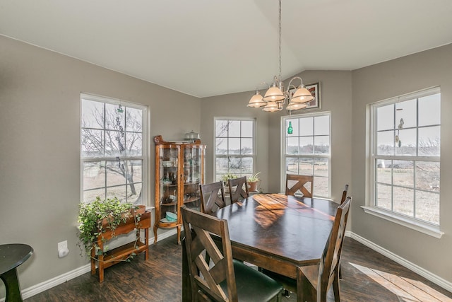 dining room with dark hardwood / wood-style flooring, lofted ceiling, and an inviting chandelier