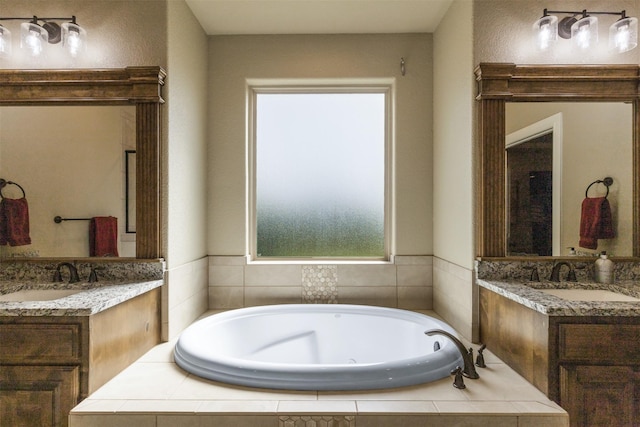 bathroom with tiled tub and vanity