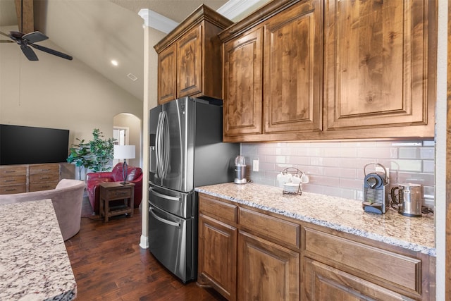 kitchen with lofted ceiling, backsplash, dark hardwood / wood-style floors, stainless steel refrigerator with ice dispenser, and light stone counters