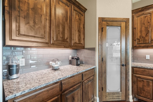 kitchen featuring backsplash and light stone counters