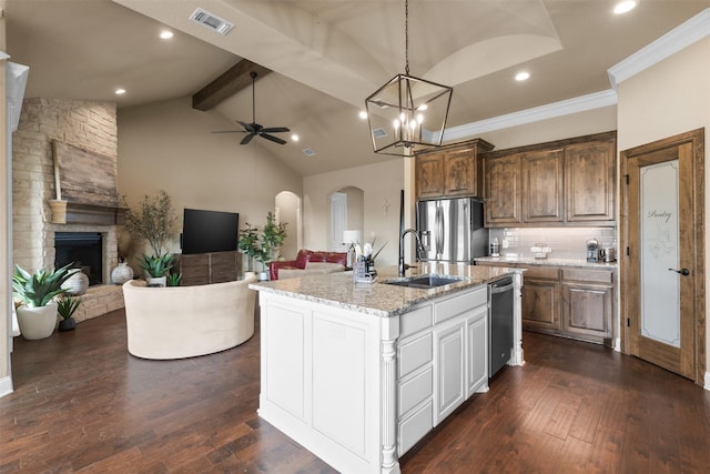 kitchen featuring tasteful backsplash, sink, stainless steel appliances, and an island with sink