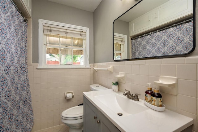 bathroom with toilet, a shower with shower curtain, tile walls, and vanity