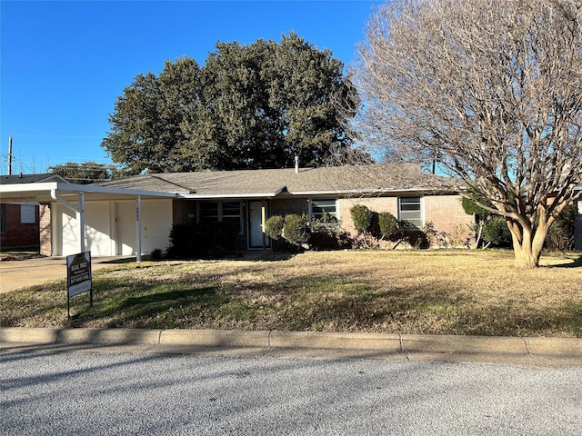 single story home featuring a front lawn and a carport