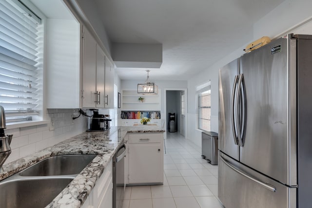 kitchen featuring decorative light fixtures, white cabinets, appliances with stainless steel finishes, and sink