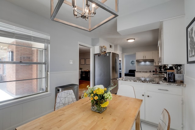 dining space with sink and a chandelier