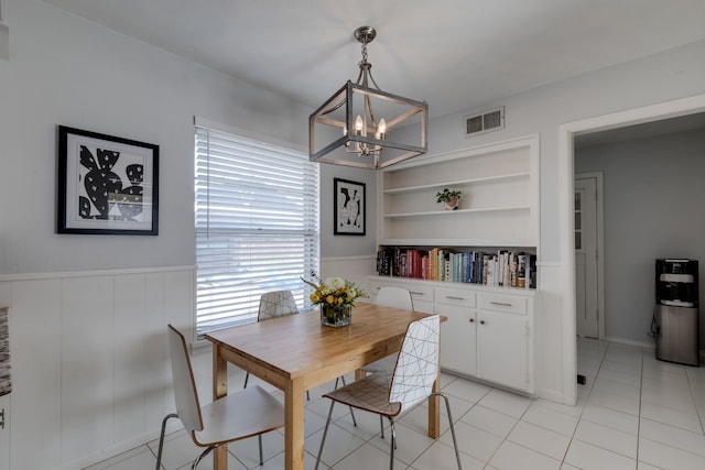 dining area featuring a notable chandelier, built in shelves, and light tile patterned floors