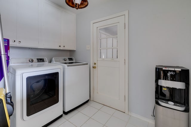 laundry area featuring washer and dryer, cabinets, and light tile patterned floors