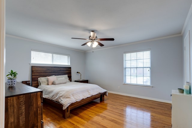 bedroom with crown molding, multiple windows, light hardwood / wood-style flooring, and ceiling fan