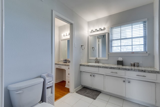 bathroom with toilet, tile patterned floors, and vanity