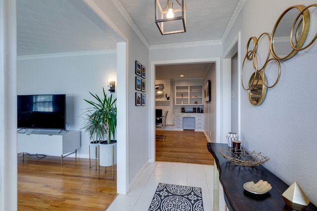 corridor featuring built in features, light tile patterned floors, and ornamental molding