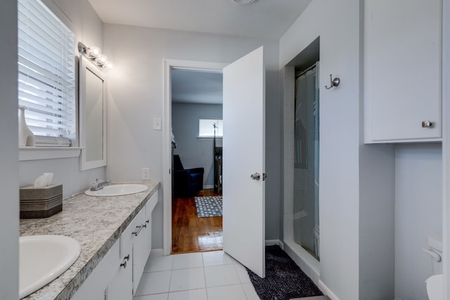 bathroom featuring walk in shower, vanity, and tile patterned flooring