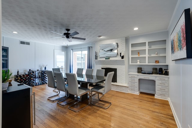 dining room featuring ceiling fan, light hardwood / wood-style flooring, crown molding, and built in desk