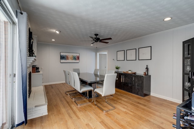 dining area with crown molding, light hardwood / wood-style floors, and a textured ceiling