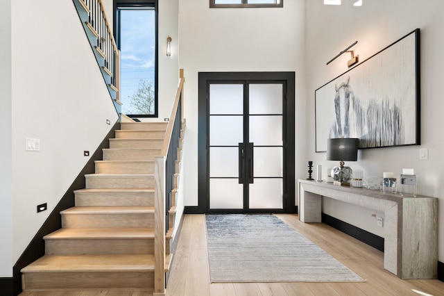 entrance foyer with light hardwood / wood-style floors and french doors