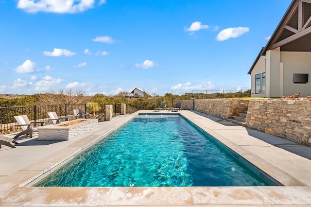 view of pool with an outdoor fire pit and a patio