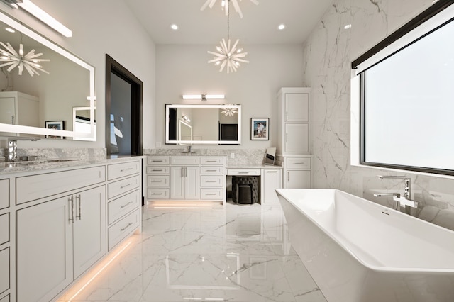 bathroom featuring vanity, a bathtub, and a chandelier