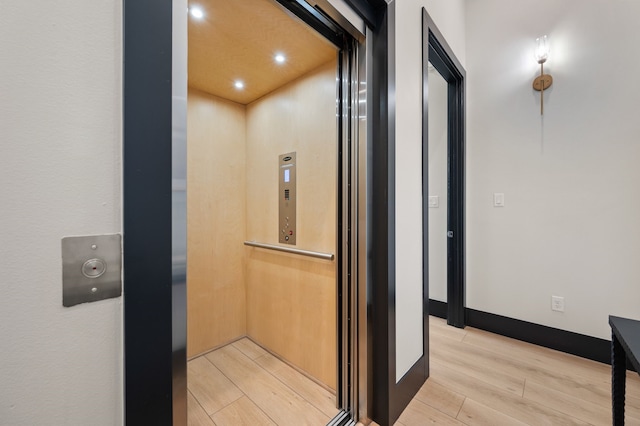 interior details with elevator and hardwood / wood-style floors