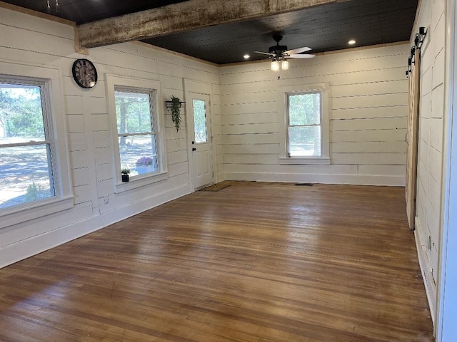 entryway featuring ceiling fan, a barn door, dark hardwood / wood-style floors, and beamed ceiling