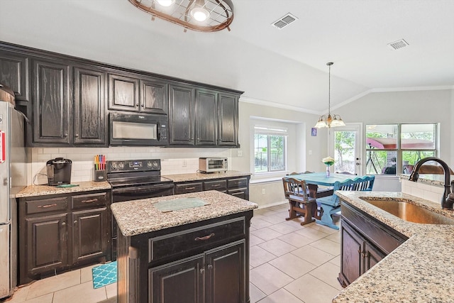 kitchen featuring lofted ceiling, backsplash, black appliances, and a kitchen island