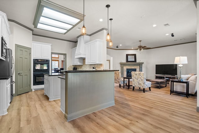 kitchen featuring black double oven, backsplash, white cabinetry, and ornamental molding