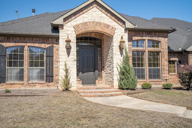 view of exterior entry with a lawn