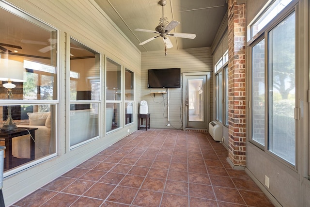 unfurnished sunroom featuring ceiling fan