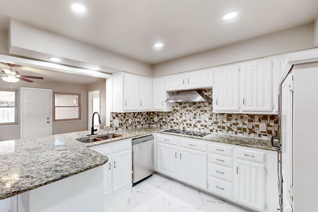 kitchen featuring white cabinetry, stainless steel dishwasher, sink, kitchen peninsula, and wall chimney exhaust hood