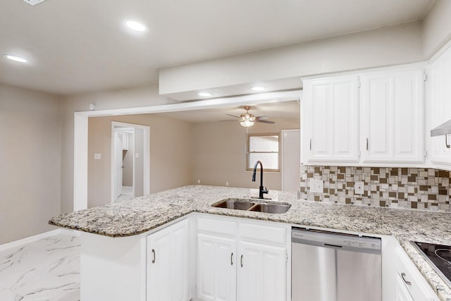 kitchen with sink, dishwasher, white cabinetry, and kitchen peninsula