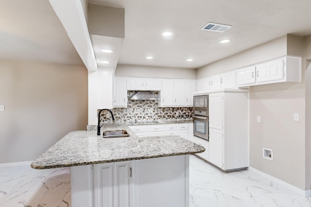 kitchen featuring appliances with stainless steel finishes, white cabinetry, sink, kitchen peninsula, and wall chimney exhaust hood