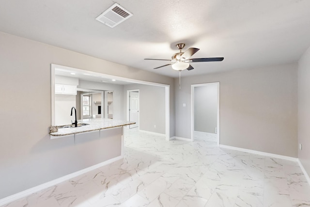 spare room featuring sink and ceiling fan