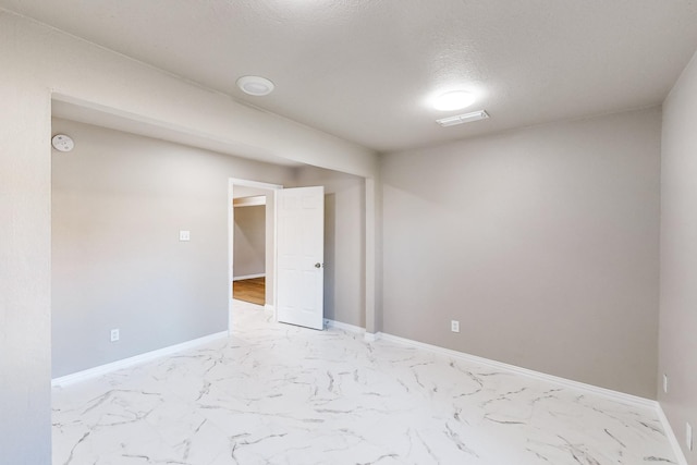 spare room with a textured ceiling